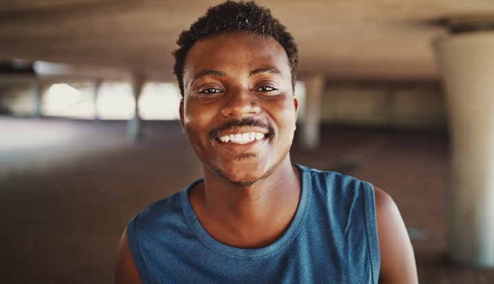 Hombre negro sonriente con bigote fino