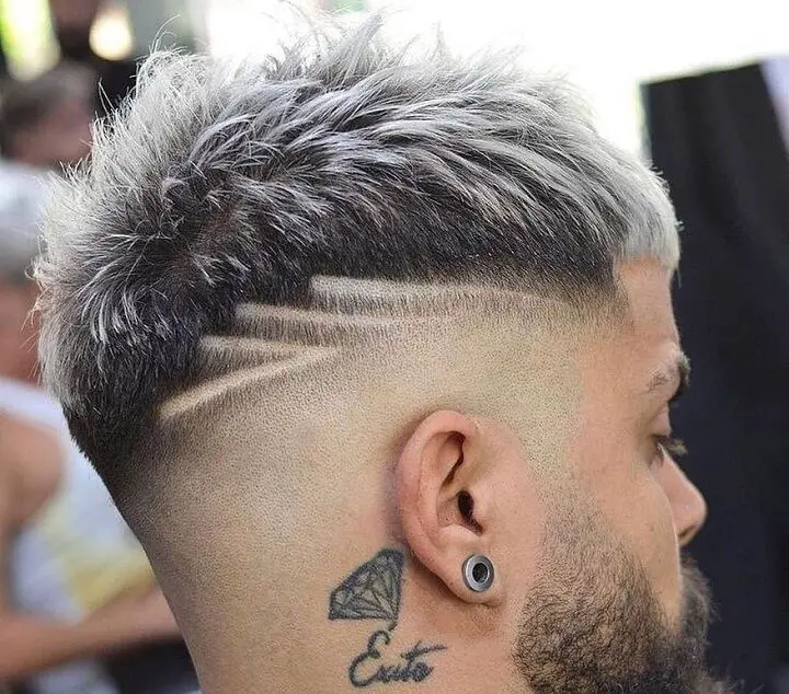 Corte de pelo decolorado en punta con líneas de diseño